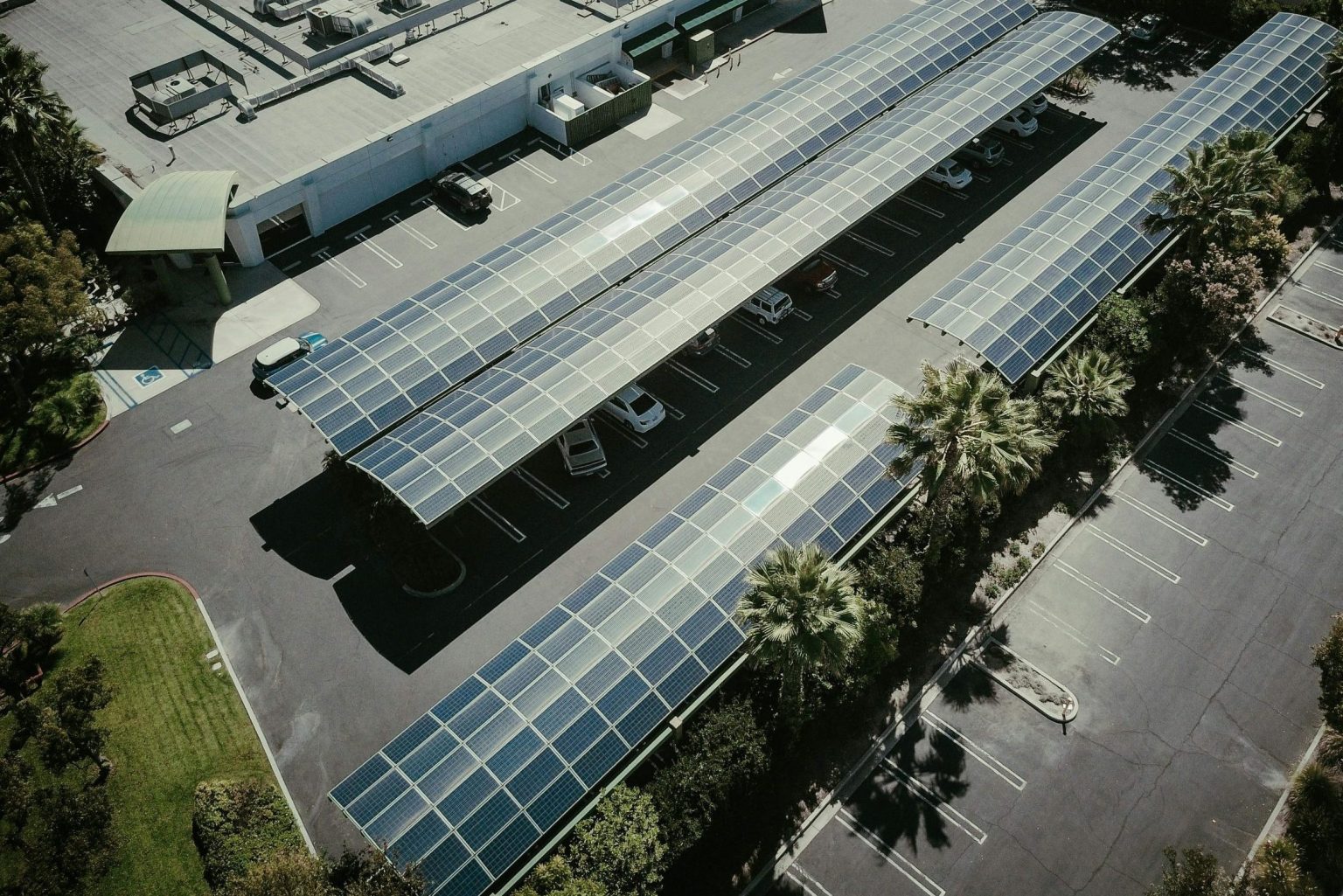 Aerial view of solar panels on a parking lot roof, showcasing renewable energy.